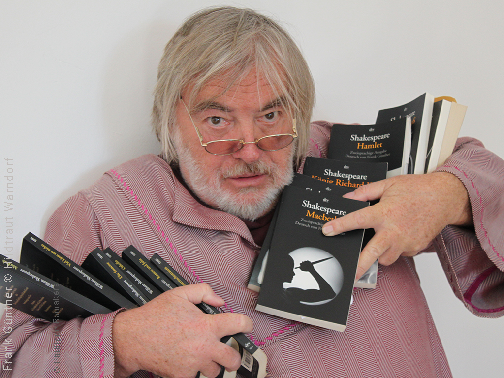 Foto von Übersetzer Frank Günther mit Shakespeare-Büchern in den Armen.