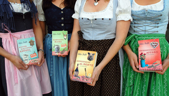 Foto von vier Frauen im Dirndl mit je einem Band der Eberhofer-Reihe.